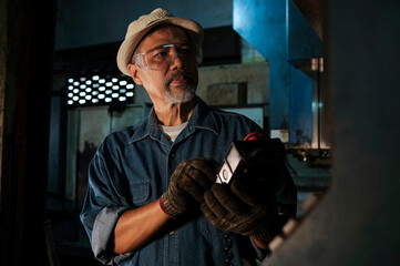 Asian mechanic inspecting and using equipment for maintenance of press machine at industrial work concept workers factory.