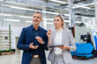 © Westend61 - Businesswoman with digital tablet and businessman talking in factory