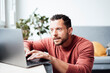 © Westend61 - Curious working man using laptop at home office