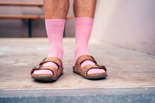 Legs Of Man Standing On Floor Wearing Pink Socks And Sandals