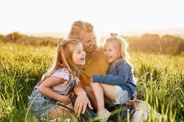 Mom with two daughters spending time together at the meadow