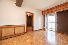 Empty Room With White And Dark Brown Painted Walls, Oak Parquet Flooring And Wooden Radiator Cover And Wicker Lattice