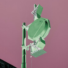 An Advertising Sign With Arrows And Lights On A Post, Inverted Image, Pink Background.