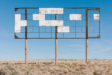 An Old Billboard, Empty Panels, In The Middle Of Desert Scrub.