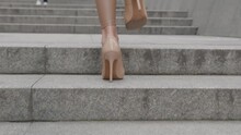 Rear Back View Feet Of Businesswoman N High-heeled Footwear Commuting To Work.. Unrecognizable Female Legs In High Heels Shoes Walking In The Urban Street Downtown.