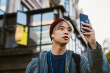 Asian Boy Taking Photo On Mobile Phone At City Street