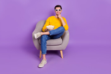 Sticker - Full size photo of young positive peaceful man watch 3d film enjoying yummy snack isolated on violet color background