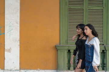 Two girls talking while strolling on the street