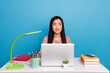 © deagreez - Portrait of minded pretty thai girl sitting desk look interested empty space isolated on blue color background