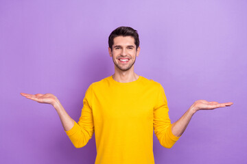 Poster - Photo of good mood positive male compare two different product promotion isolated on violet color background