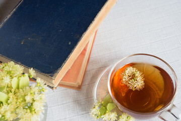 Sticker - Linden herbal tea on a light pastel background. Old books. Copy space