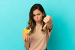 © luismolinero - Young woman holding fried chips over isolated background showing thumb down with negative expression