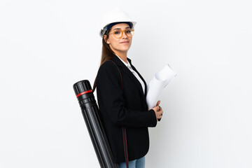 Sticker - Young architect caucasian woman with helmet and holding blueprints over isolated background laughing