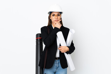 Wall Mural - Young architect caucasian woman with helmet and holding blueprints over isolated background thinking an idea