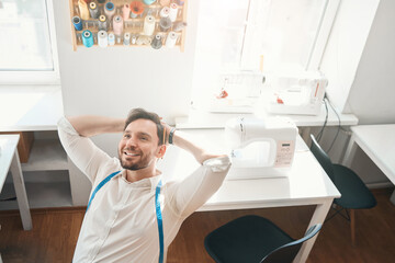 Wall Mural - Happy young fashion designer having rest in atelier