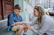 © Halfpoint - Mother consoling her little son on his first day of school,sitting on stair and saying goodbye before school.