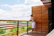 © Andrii  - Attractive successful naked man in a towel stands on a terrace overlooking the picturesque nature