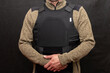 A muscular military man in a bulletproof vest on a black background.