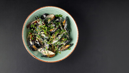 Wall Mural - a bowl of mussels, with herbs and sauce top view on a black table