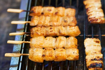 Wall Mural - Close up of barbecue grill salmon skewers on wooden sticks, thai street food market