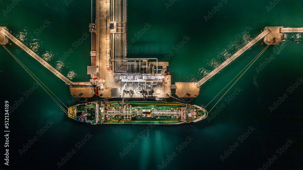 Aerial top view oil tanker ship at terminal industrial port at night ...