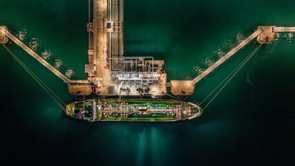 Wall Mural - Aerial top view oil tanker ship at terminal industrial port at night for transfer crude oil to oil refinery, Business import export oil and gas petrochemical.