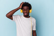 © Asier - Young african american man listening to music isolated on blue background being shocked, she has remembered important meeting.
