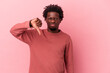© Asier - Young african american man isolated on pink background showing thumb down, disappointment concept.