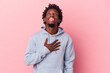 © Asier - Young african american man isolated on pink background laughs out loudly keeping hand on chest.