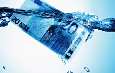 Conceptual image: Global economic and financial crisis. Euro bill sinking in water as symbol of uncertain future of international trade and investment. Horizontal image.