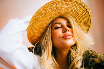 Portrait of attractive caucasian woman in a hat wearing fur coat and stylish outfit.