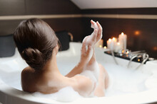 Young Woman Taking Bubble Bath, Back View. Romantic Atmosphere