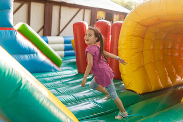 Wall Mural - A cheerful child plays in an inflatable castle