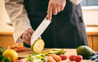 © Rawf8 - Chef cut zucchini with a knife on a chopping board, close up. Fresh vegetable on kitchen table.