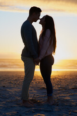 Wall Mural - Youre nothing short of my everything. Silhouette shot of a young couple on the beach.