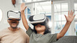 © N Felix/peopleimages.com - It looks so real. Shot of a little boy and his father wearing VR glasses at home.