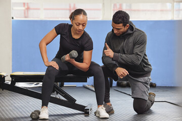 Poster - He keeps me motivated to keep going. Shot of a young woman exercising with a trainer at the gym.