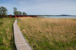 Wooden walkway on a field on the coast in Mariehamn, Åland Islands, Finland, on a sunny day.