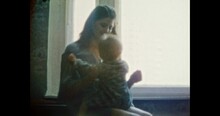 Happy Mother Having Fun With Laughing Child In Room. Cheerful Young Woman Hugging Smiling Baby Girl Near Window Home. Fanny Family Life Indoors. Vintage Color Film. Family Archive. Retro 1980s. 4k