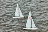 Fototapeta Łazienka - small radio-controlled sailing boats sailing on water, boat numbers on sails