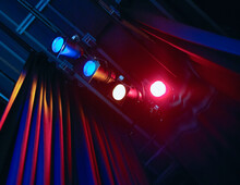 Coloured Spotlights Shining Past Curtain In Theatre