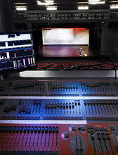 Looking From Control Panel For Sound And Lighting Towards Person Sweeping Stage In Theatre