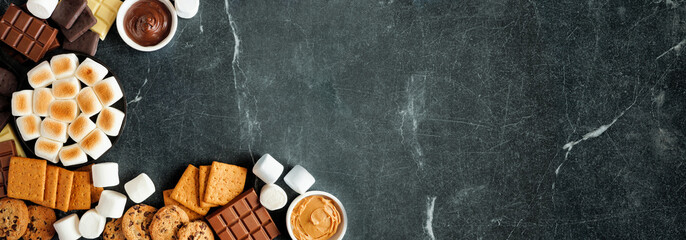 Poster - Smores buffet corner border. Roasted marshmallows, crackers, chocolate and a variety of ingredients. Overhead view over a dark stone background.
