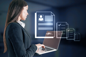Poster - Online recruiting and hiring employee concept with woman in suit side view using laptop and hologram resume or CV on dark background