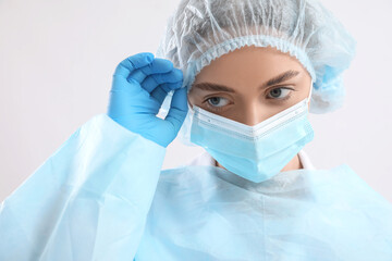 Wall Mural - Female surgeon on light background