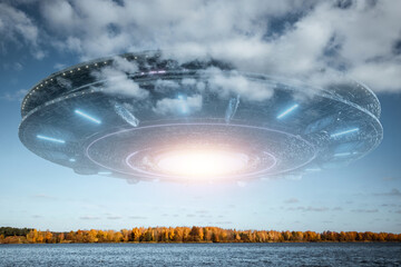 Wall Mural - ufo, an alien saucer hovering above the lake in the clouds, hovering motionless in the sky. unidenti