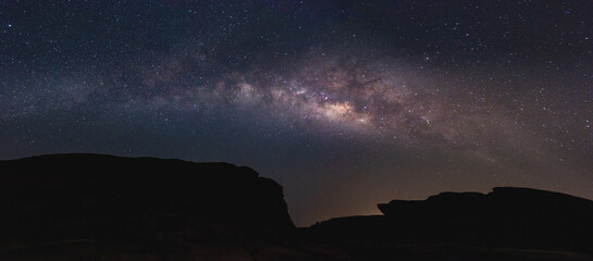 Wall Mural - milky way in the night sky and stars on dark background with noise and shadows of mountains. photo t