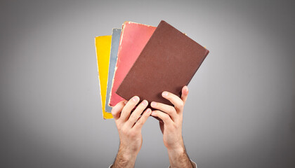 Wall Mural - Male hand holding book on grey background.
