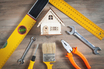 Work tools with a wooden house model.