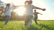 kids run in the park. a large group of a team of children running back view sunlight in the summer on the grass in lifestyle the park camera movement. people in the park happy family kid dream concept